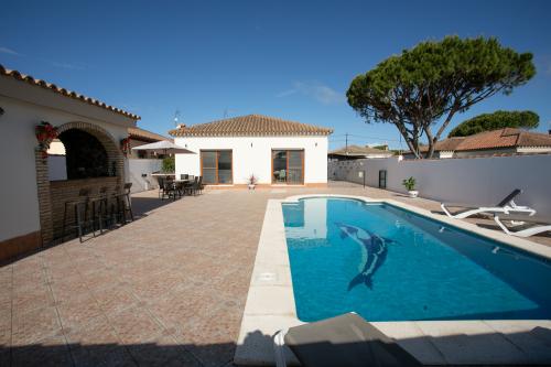Zona de piscina con la casa